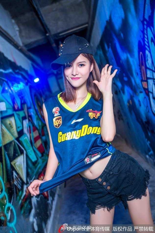 一位篮球宝贝回眸一笑，精致的妆容与闪亮的眼神交相辉映，碎边短裙的灵动质感衬托出她的青春活力，成为赛场边最甜美的定格。