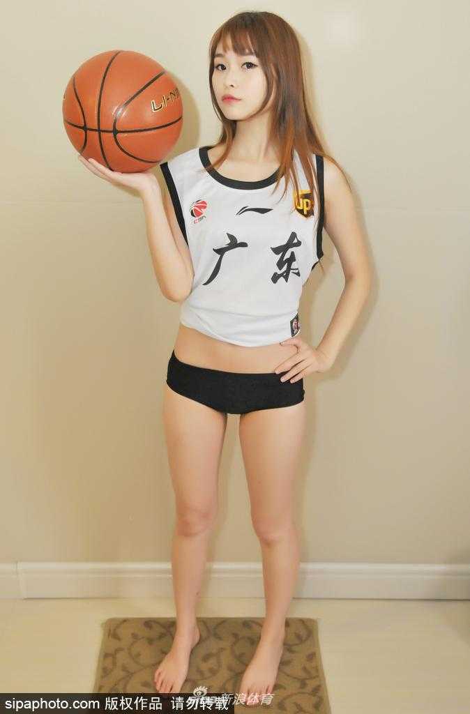 熊熙手捧足球坐在草坪上，微风拂过发梢，甜美的笑容里藏着对足球最纯粹的热爱。