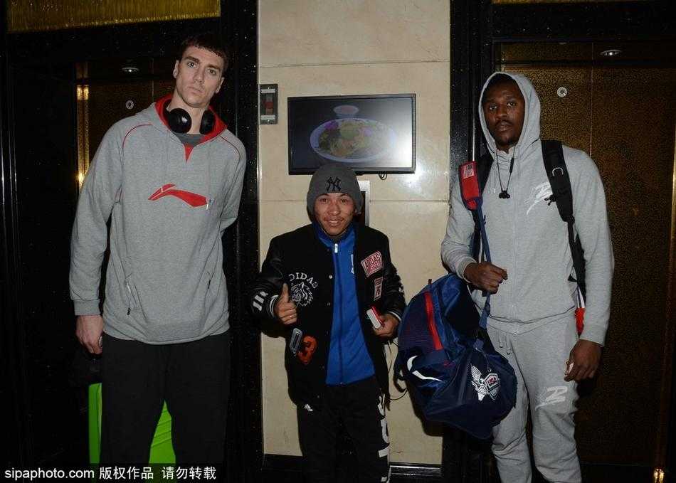 广州龙狮队抵沪,外援亲和力十足与球迷热情互动 汉斯布鲁弯腰为小朋友在篮球上签名,周围球迷纷纷举起手机记录暖心瞬间