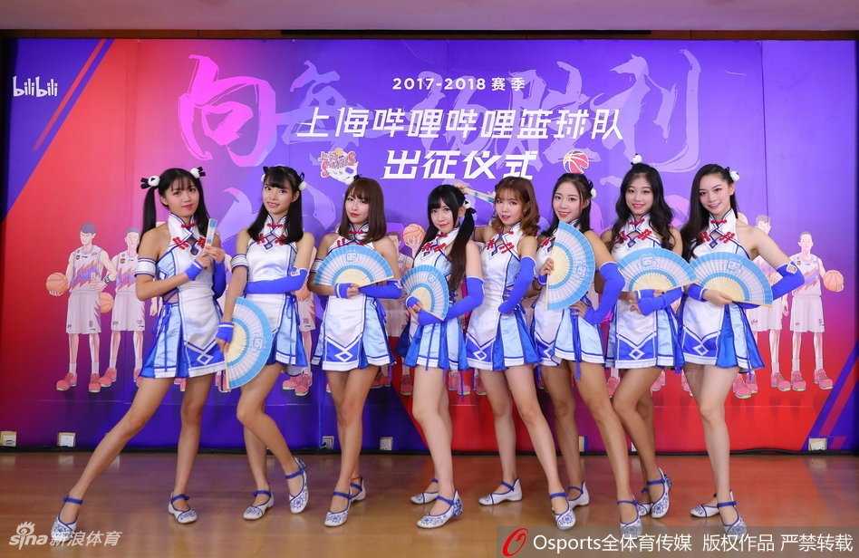 当篮球遇见二次元:上海男篮新篇章 身着水手服的啦啦队员在球场上活力四射,她们的青春气息与身后巨大的漫画版球队海报相映成趣,仿佛从二次元世界穿越而来的篮球应援团。