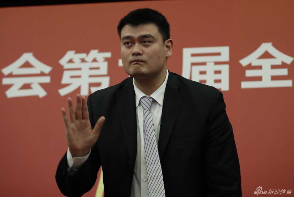 面对身边人的轻声交谈，姚明侧耳倾听，神情专注，体现了他善于听取意见、集思广益的工作作风