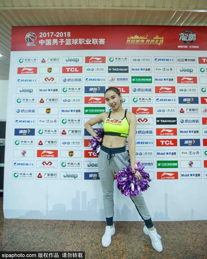 揭秘赛场边的活力风景线 探访龙狮篮球宝贝的台前幕后 即将登场,这位篮球宝贝对着镜子练习标志性的甜美微笑,身旁的队友正在调整她服装上的装饰物,细节之处体现了团队的默契与温情。