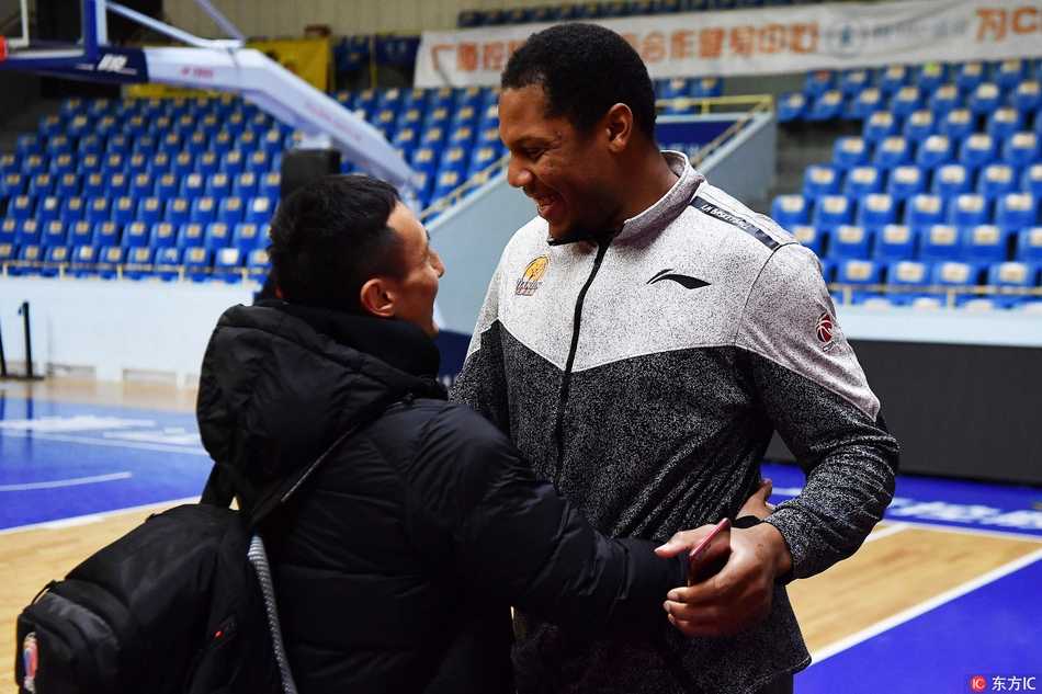 霍尔曼与广厦体能教练双手紧握，两人相视大笑，眼神中传递着无需言语的兄弟情谊