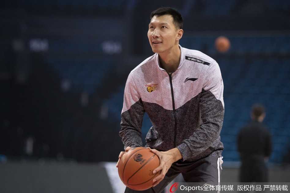 易建联在罚球线附近准备出手，整个场馆的灯光聚焦在他身上，队友们排成一排等待捡球继续投篮。