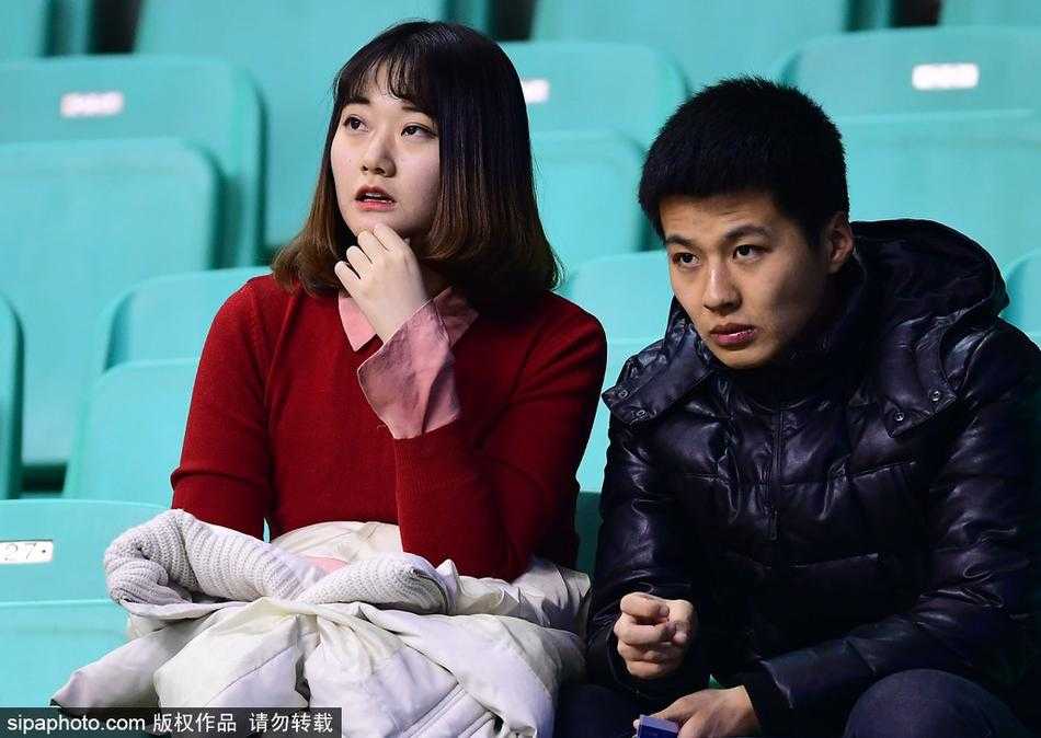 尽管比赛紧张激烈，彩虹发美女依然神情专注地看着场内，她的侧颜在球场顶灯的映照下显得格外精致，那头彩辫仿佛也随着比赛的节奏跳跃。