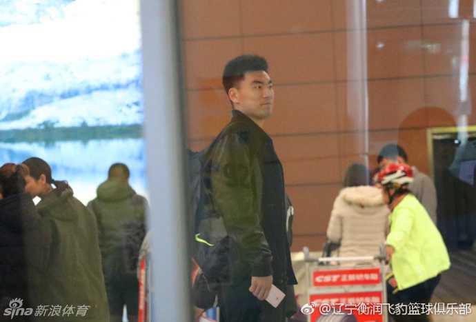在沈阳桃仙国际机场，李晓旭身着黑色休闲装，推着满载而归的行李车，脸上洋溢着回家的轻松笑容，俱乐部代表上前为他送上鲜花表示欢迎。