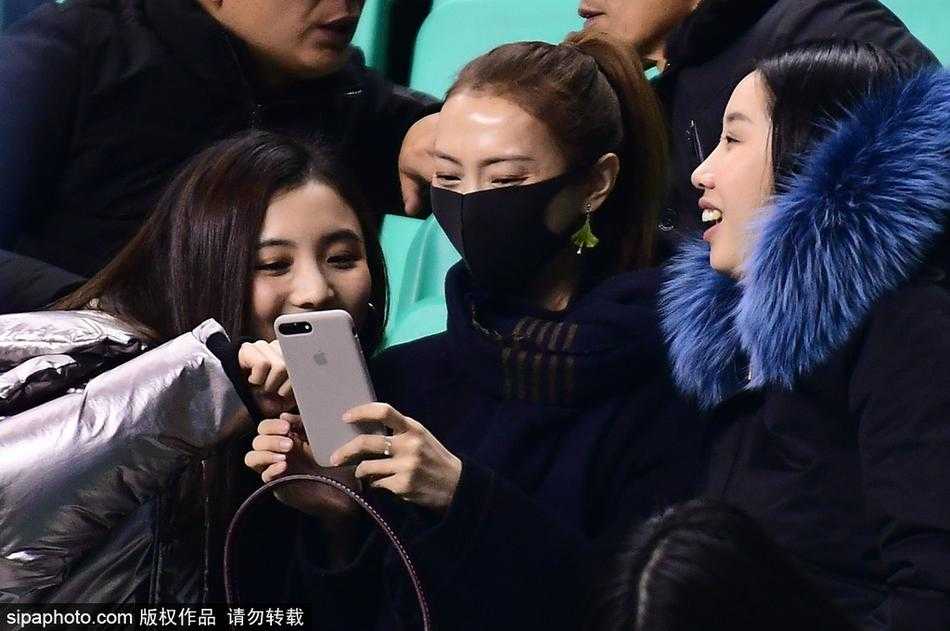 看台上的李旭神情专注，当李晓旭打进精彩进球时，她难掩激动之情起身鼓掌，美丽的脸庞上洋溢着自豪与喜悦。