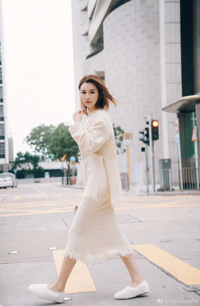 阳光透过树叶的缝隙洒在王星洋精致的侧颜上，她轻倚栏杆，姿态闲适，举手投足间流露出一股不经意的优雅与知性美。