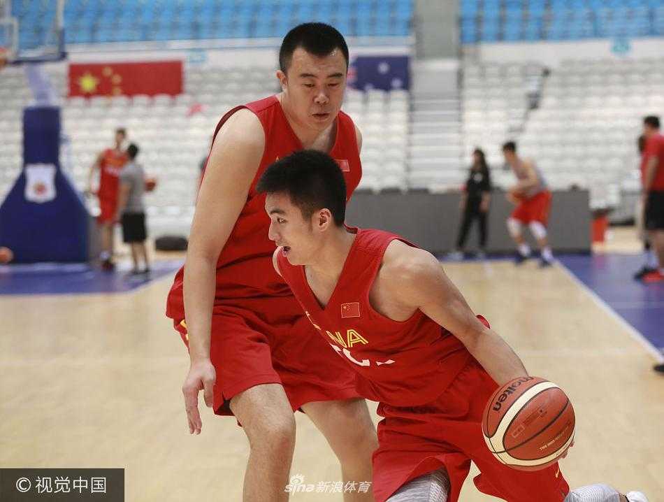 教练组围在一起讨论战术，杜锋站在中间拿着战术板写写画画，球员们或弯腰倾听，或点头领会，团队凝聚力在这一刻尽显。