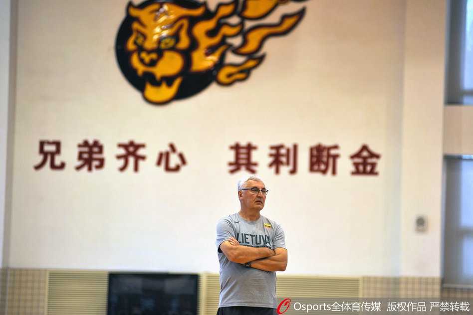 欧洲凯撒的回归·华南虎新篇 尤纳斯重掌广东宏远 训练场上,年轻球员们在尤纳斯的注视下进行折返跑,汗水洒在地板上,背景中“广东宏远”的标语格外醒目,象征着球队在新老交替中迈向未来