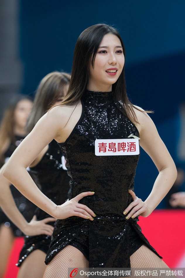 在场地中央，一位篮球宝贝高高跃起，修长的双腿在空中划出优美的弧线，仿佛挣脱地心引力，将她无尽的活力与热情毫无保留地传递给看台上的每一位观众。