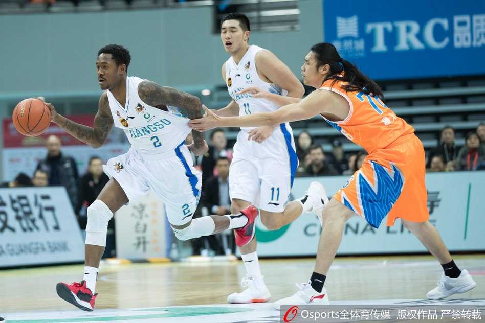 赢球后的江苏球员们围在一起，击掌相庆，笑容洋溢在每一个人的脸上，这是团队篮球的胜利。