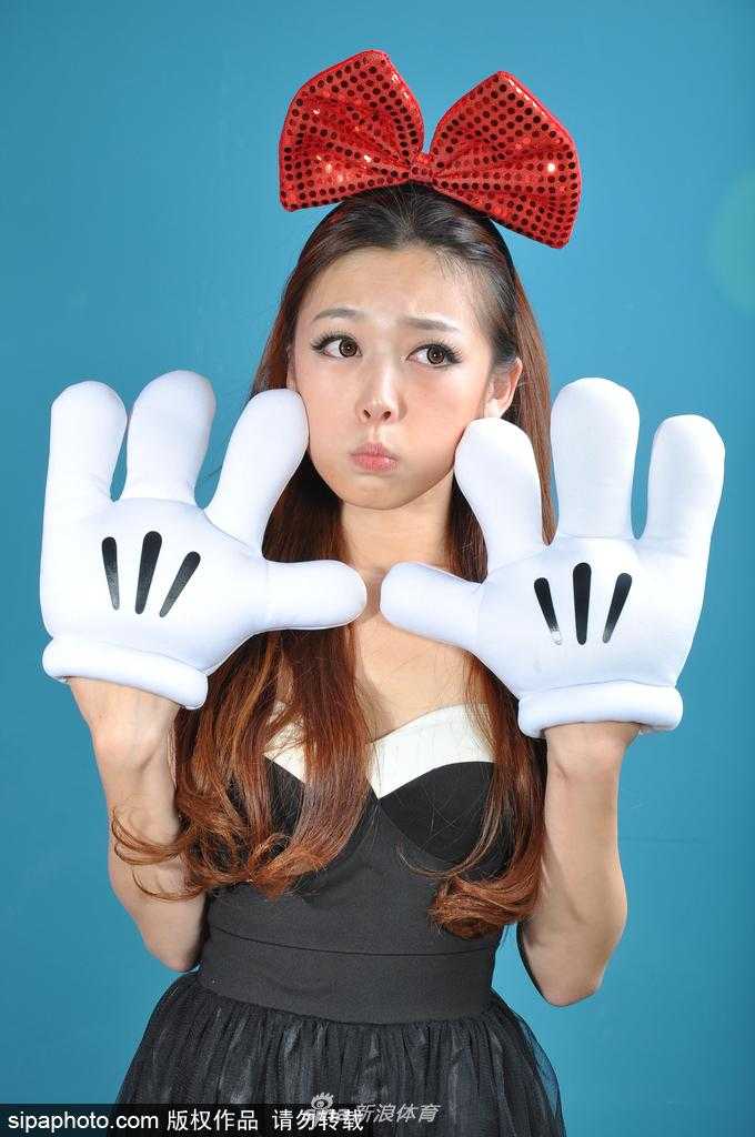 一位宝贝在退场时对着镜头调皮地眨眼睛，白色的运动上衣配着红色的蝴蝶结，将她衬托得既清纯又充满活力，让人忍不住多看几眼。