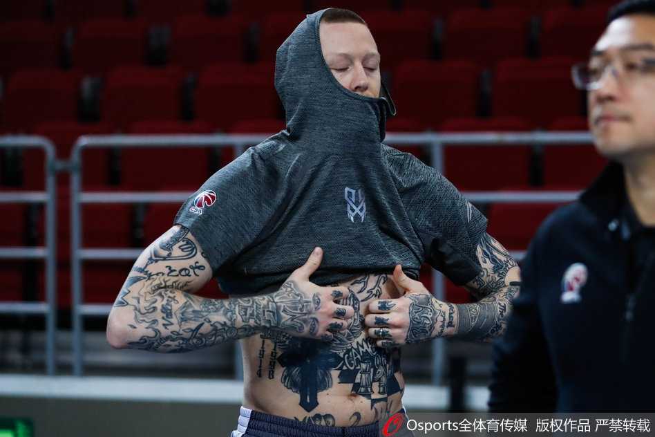 队长张兆旭在篮下全力起跳，手臂高扬试图触碰篮球，眼神坚毅地守护着禁区最后的领地。