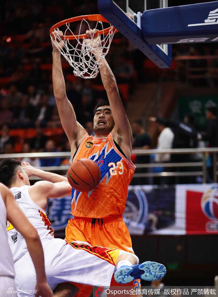 上海队中锋张兆旭高高跃起，双手将球狠狠地砸进篮筐，展现出内线绝对的统治力，眼神中充满霸气。