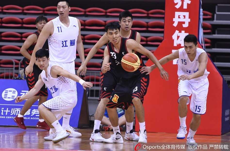 津门决:全运会男篮小组赛江苏逆转天津,易立关键时刻主宰比赛 易立在防守球员的围堵下依然冷静地将球传给队友,眼神中透露出必胜的信念。