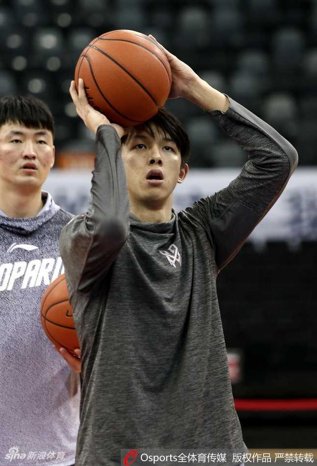 主教练王建军手持战术板，亲自为队员们讲解跑位路线，他的手势坚定有力，队员们围在身边认真聆听，整个教练组与球员们融为一体，共同备战。