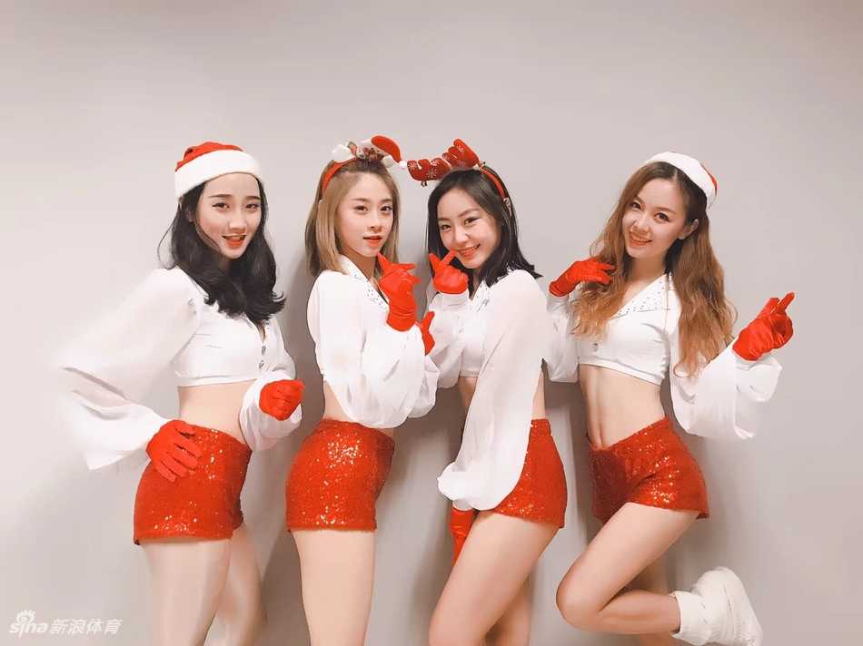 深圳男篮炫舞团甜心宝贝 圣诞夜热力绽放 甜心宝贝头戴毛绒圣诞帽,对着镜头俏皮眨眼,手中金色的花球与红色装扮相映成趣,洋溢着满满的节日元气。