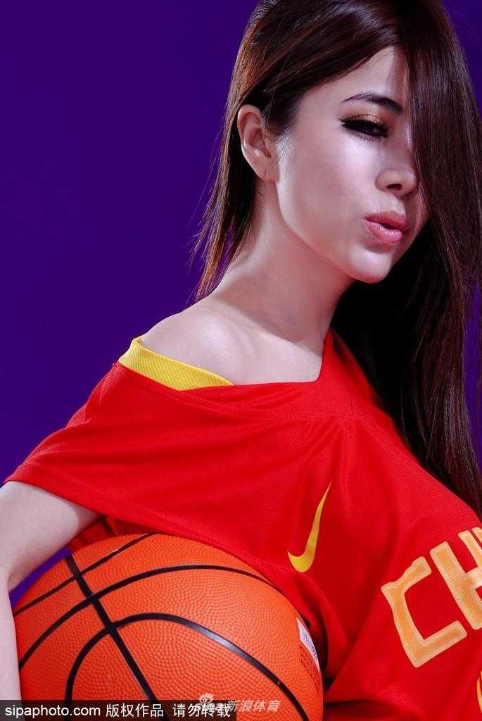 近景镜头下，袁颖芬轻咬下唇，眼神俏皮而充满力量，微露的香肩和精致的锁骨成为视觉焦点，传递出对男篮力挺到底的活泼决心。