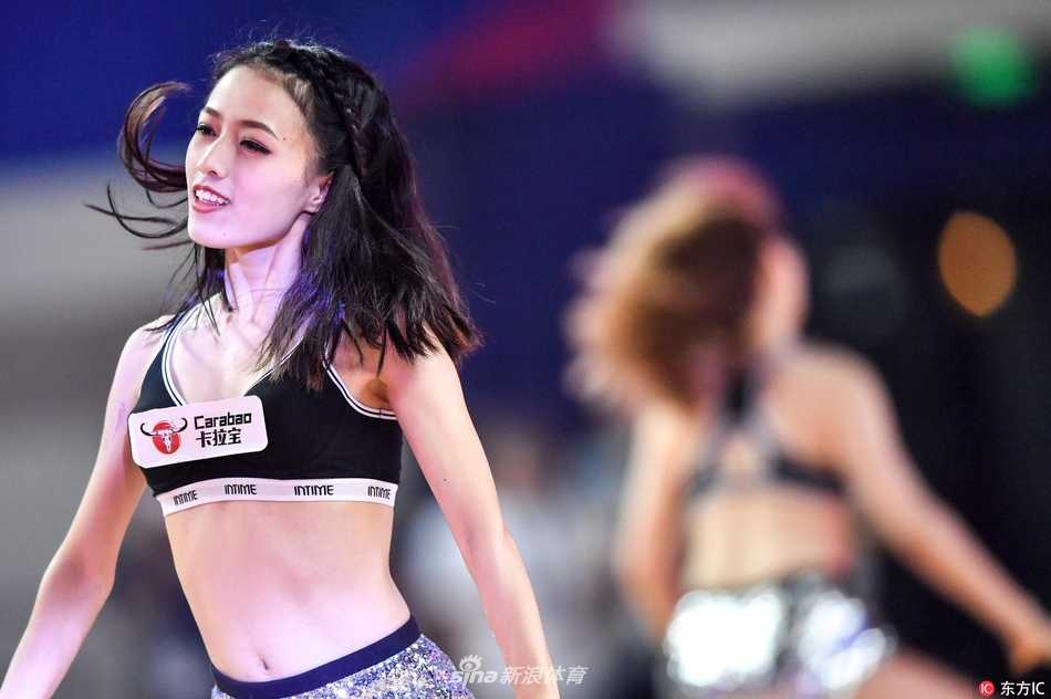 身着统一亮黄色短裙的拉拉队员们排成整齐的队列，在动感的音乐节奏中做出整齐划一的踢腿动作，她们的身影与地板上的倒影交相辉映，构成一幅充满活力的画面