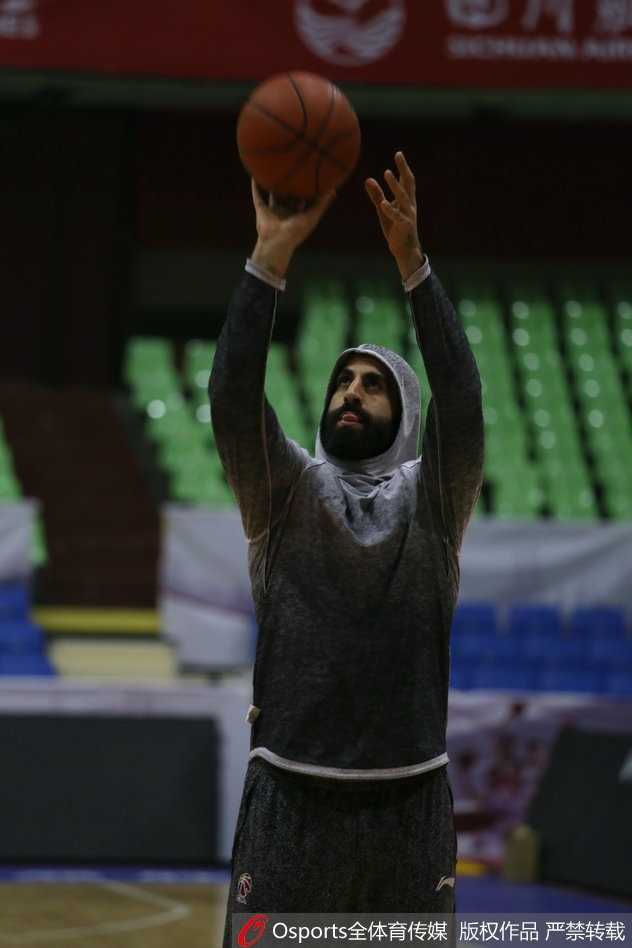 广州队核心后卫在训练中眼神坚毅，汗水浸透球衣，正组织队友进行战术演练。