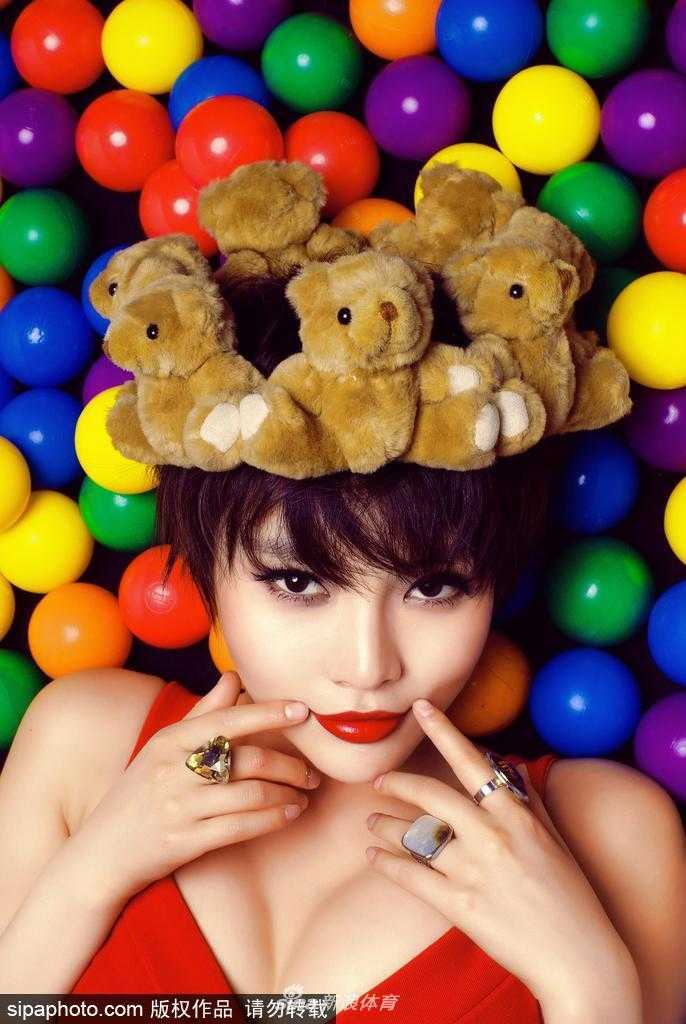 她侧身而坐，双腿盘起将篮球轻轻放在膝上，目光温柔地望向远方，宛如球场边的一幅静态油画