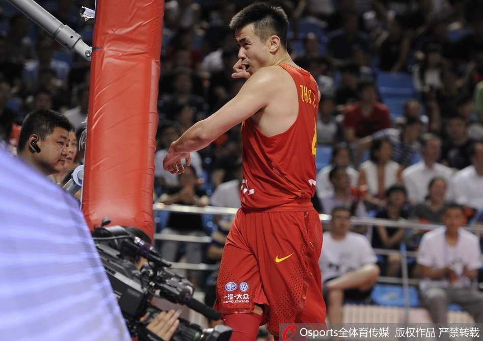 上篮动作在空中完成，赵继伟的身体与防守球员发生剧烈接触，他的面部肌肉紧绷，全部注意力都集中在指尖即将送出的篮球上。