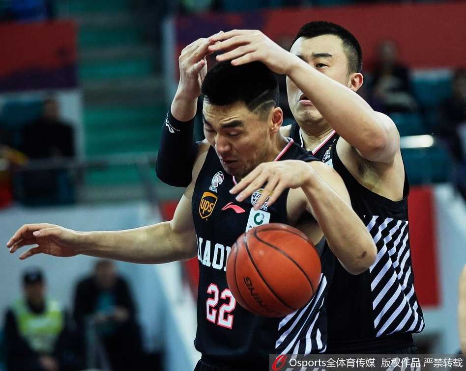 新疆队球员在对方内线球员头顶强势摘下一个前场篮板，肌肉线条在对抗中尽显力量美感