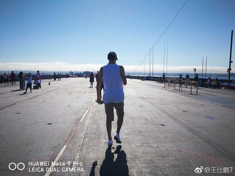 王仕鹏的圣地亚哥漫游记:从航母甲板到日落巨轮的梦幻一日 巴尔博亚公园的标志性钟楼在午后的阳光下显得庄重而优雅,王仕鹏站在西班牙殖民复兴风格的拱门走廊下,抬头仰望精美的建筑细节。