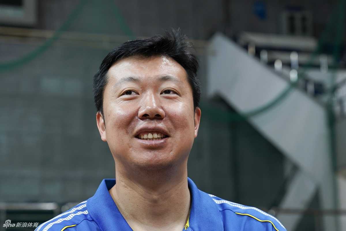 大郅面带微笑耐心解答小球员的提问，眼神中满是过来人的温和与鼓励