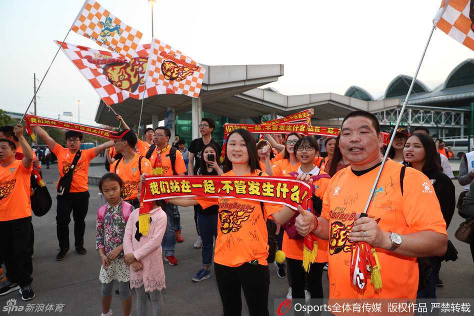 球迷热情接风,华南虎踏上逆袭征途 面带微笑的朱芳雨虽然难掩长途飞行的倦色,但面对热情的球迷,他依然耐心地停下脚步,在照片上认真签名。