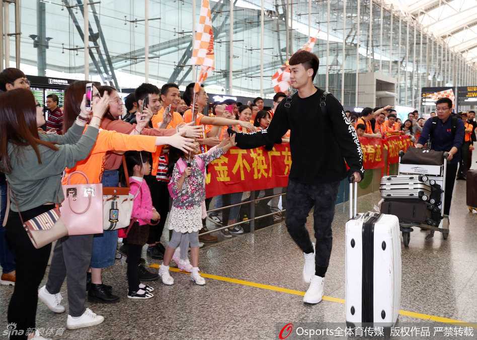 球迷热情接风,华南虎踏上逆袭征途 身穿黑色训练服的周鹏面带笑意,主动伸出右手与护栏旁伸来的球迷手掌用力击掌,气氛热烈而和谐。