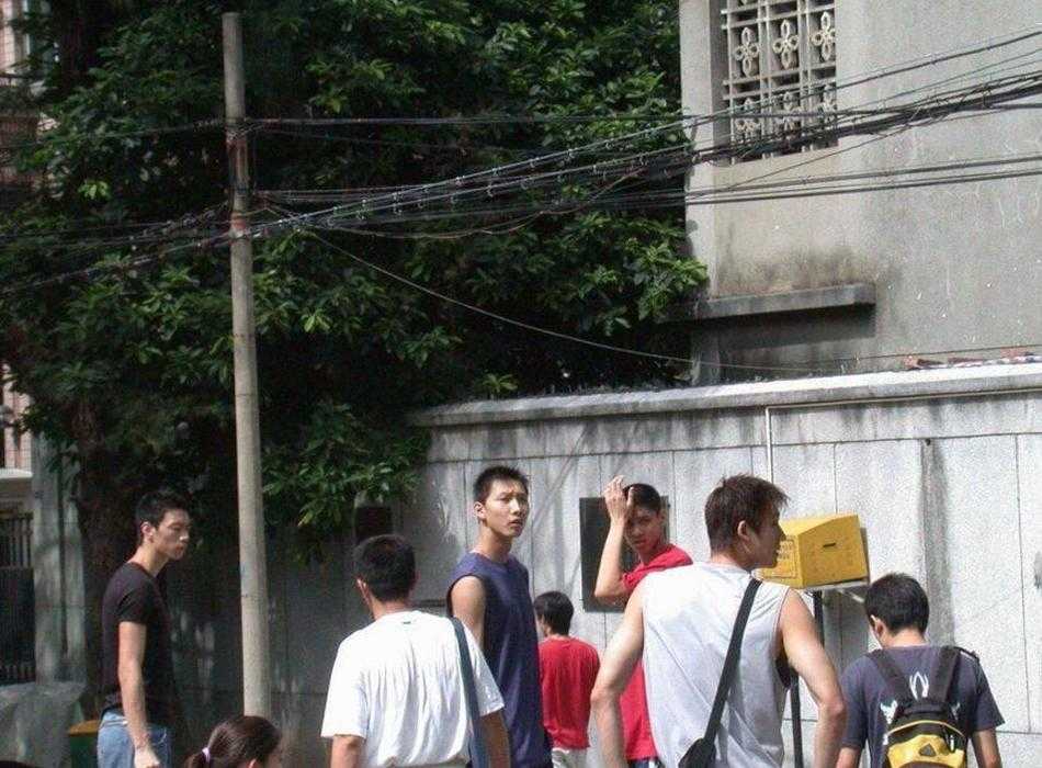 身着深色运动外套的易建联，在考场外接受记者采访，他低头看着手中的考试袋，神情认真，似乎在回想刚才的考题答得对不对。