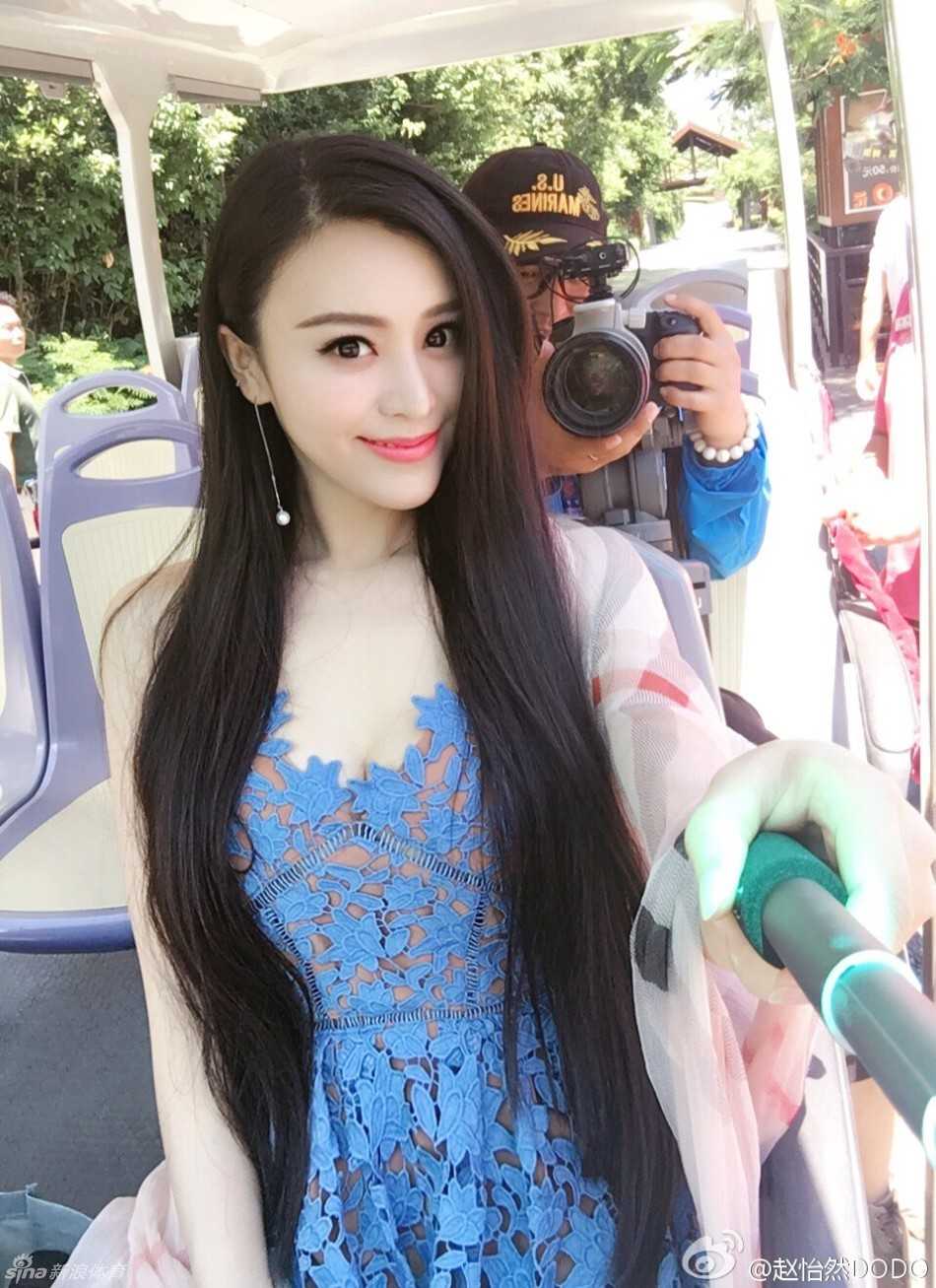 机车旁，她绽放灿烂笑容，紧身上衣难掩傲人曲线，香肩在阳光下泛着光泽，帅气与妩媚在她身上完美融合。