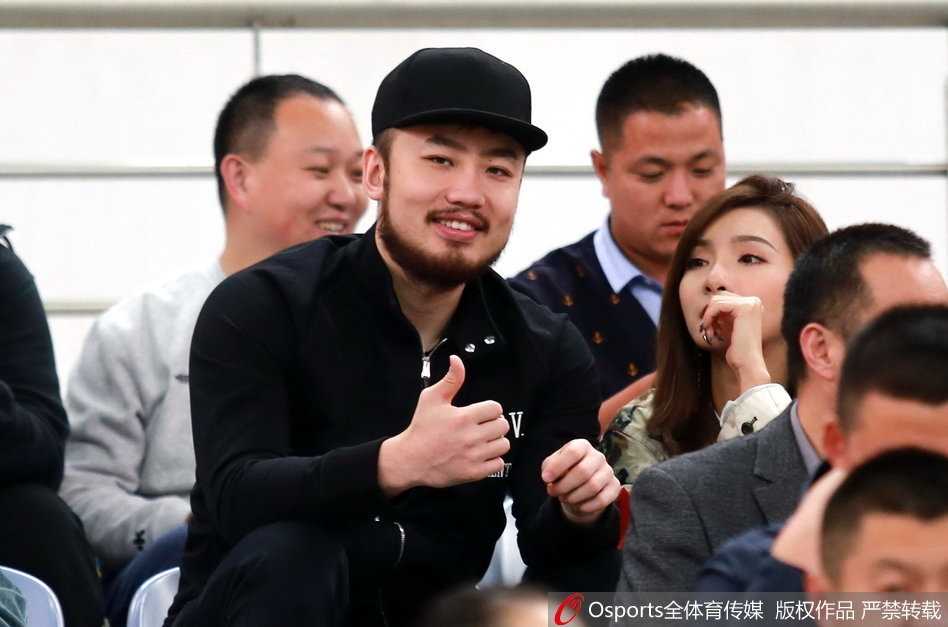 睢冉面带标志性大胡子，身穿休闲装与妻子现身看台，两人眼神中充满对比赛的期待，仿佛一对普通的球迷夫妻。