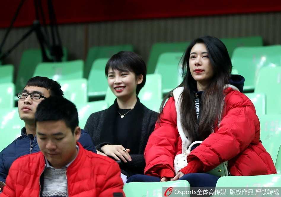 身着红色卫衣的女生扎着清爽马尾，露出灿烂的笑容比出胜利手势。她仿佛在用整个青春为支持的球队助威，那股发自内心的喜悦感染着周围每一个人。