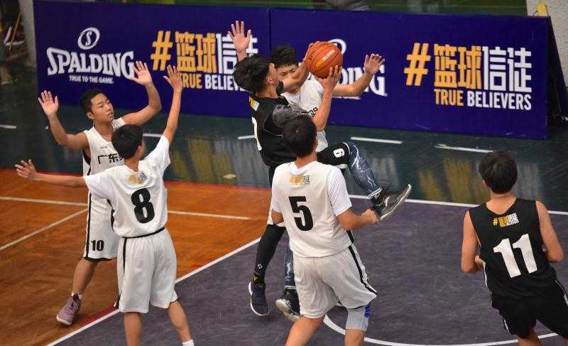 篮球信徒 闪耀广雅——重温2017广州初中男篮联赛巅峰一战 云山学校两名队员在禁区筑起铜墙铁壁,他们高高跃起,伸展长臂,用坚决的封盖试图阻挡对手的强力上篮,眼神中透出绝不退让的坚毅。