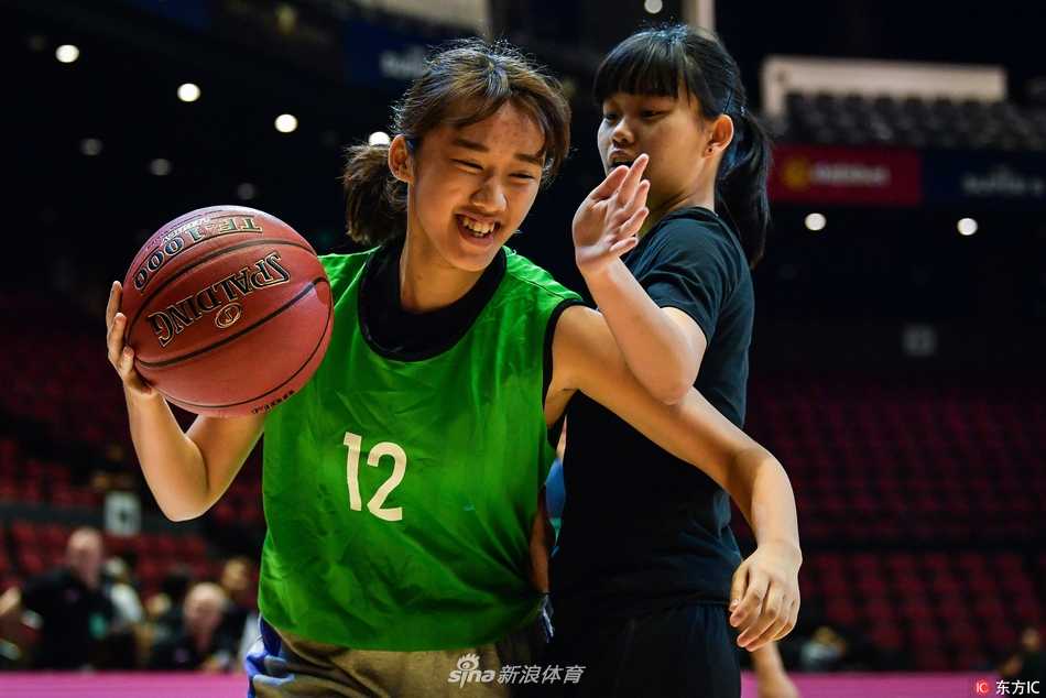 篮球新星闪耀濠江:超级八澳门邀请赛的小球员圆梦时刻 身穿红色球衣的小球员在职业赛场上毫不怯场,他正眼神坚毅地运球突破,对面的大哥哥则面带微笑认真防守,传承在这一刻悄然发生。