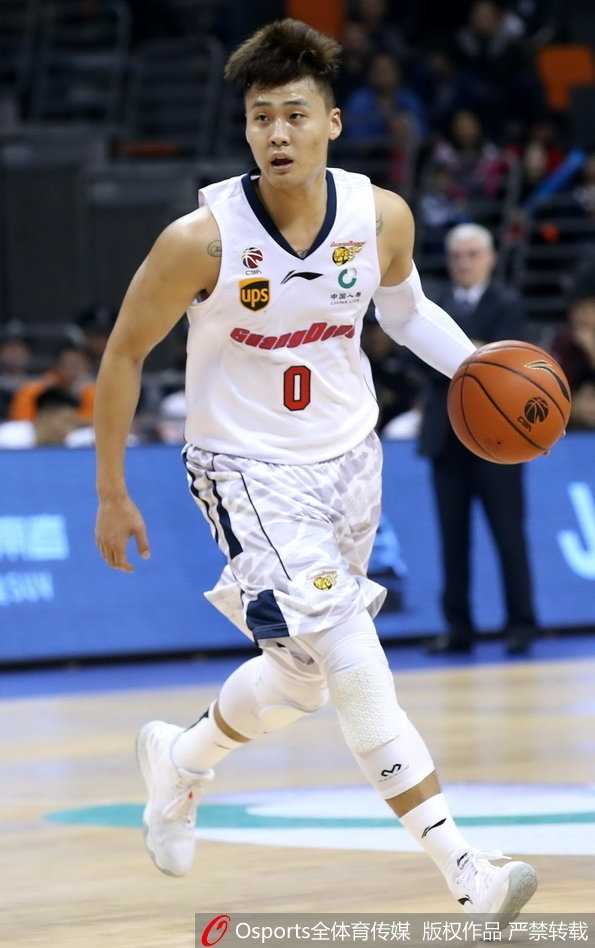 粤军主场破浪,阿联三十五分力挽狂澜奠胜局 青岛队外援吉布森在易建联的长臂干扰下强行突破上篮,尽管身体失去平衡,他依然奋力将球抛出,眼神中透露出不甘与顽强。