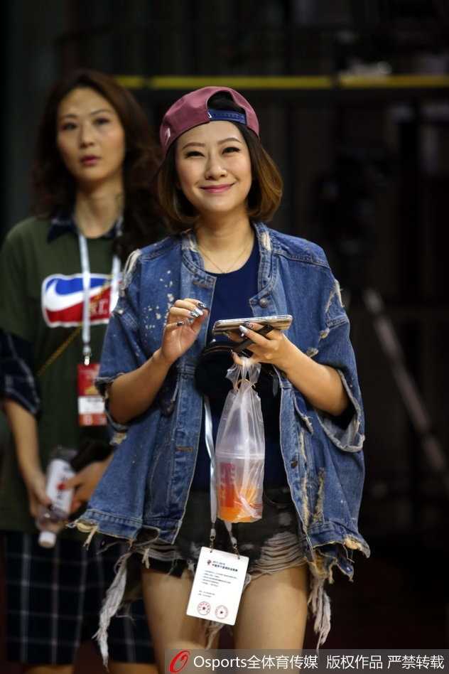 粤疆大战场边的那一抹温柔亮色 一位笑起来阳光灿烂的女球迷,对着镜头大方地展示着手中的助威棒,她的笑容为这场紧张的大战增添了无限暖意。