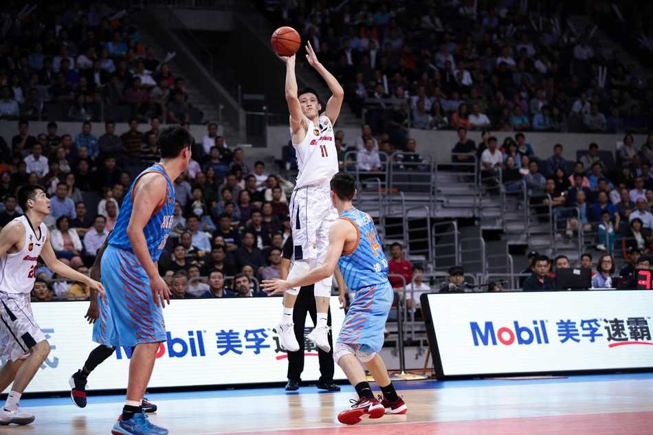 易建联在新疆队内线群中高高跃起，单臂战斧劈扣震撼全场，仿佛要将篮筐摧毁，眼神中充满了对胜利的渴望。