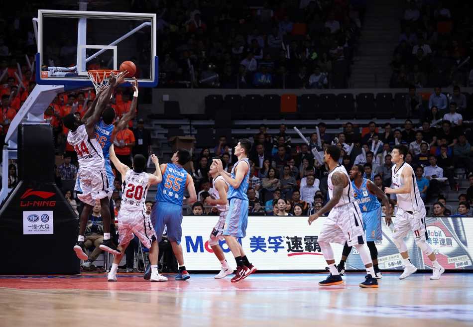 广东队小将赵睿像一把尖刀一样刺穿新疆队防线，他在空中对抗后身体完全舒展，用一记抛射将球送入篮筐，表情坚毅而无畏。