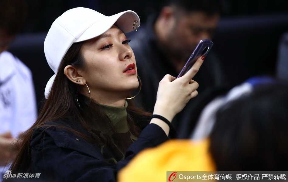 翟晓川携爱妻甜蜜亮相全明星 场边伉俪情深成星锐赛别样风景 翟晓川与妻子杨思雨坐在CBA全明星赛场边,两人都穿着深色系休闲装,神情专注地看着场内激烈的星锐赛,偶尔低声交流,眼神中满是默契与温情。