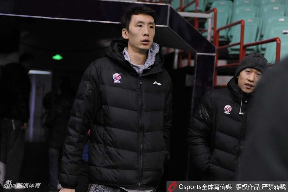 镜头拉近，可以看到哈德森眼神专注地倾听布鲁克斯说话，而身材高大的巴斯则微微低头，三人脸上都带着放松的神情，背景是肯帝亚队训练馆内忙碌的球员们。