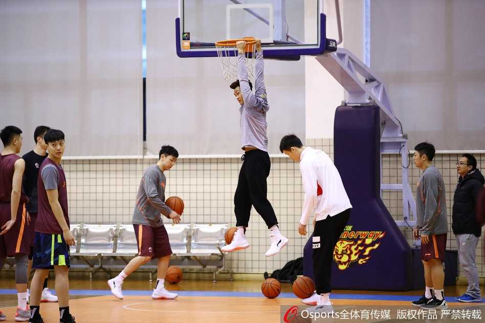 轩轩与广东宏远队全体人员合影留念，在这张充满温情的大合照中，穿着红色衣服的轩轩站在人群中央，被爱的力量紧紧包围。