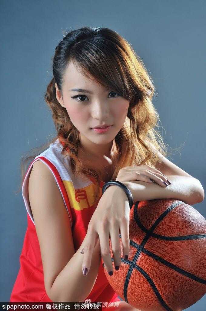 胡晓燕坐在球场边，轻撩秀发，展现迷人曲线