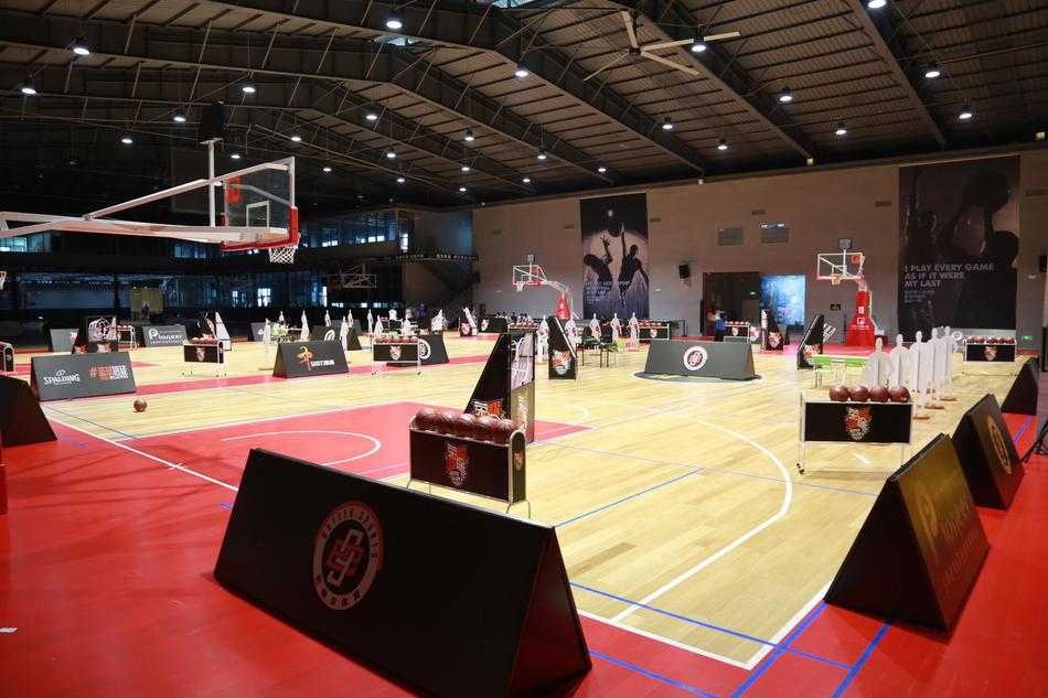 荣耀篮途深圳站:热血激战正酣,十四强进军全国总决赛 篮球名宿巴特尔身着黑色T恤,俯身与一位小球员击掌,他宽厚的肩膀像一座山,脸上却是慈父般的笑容,仿佛在说“年轻人,继续拼”。