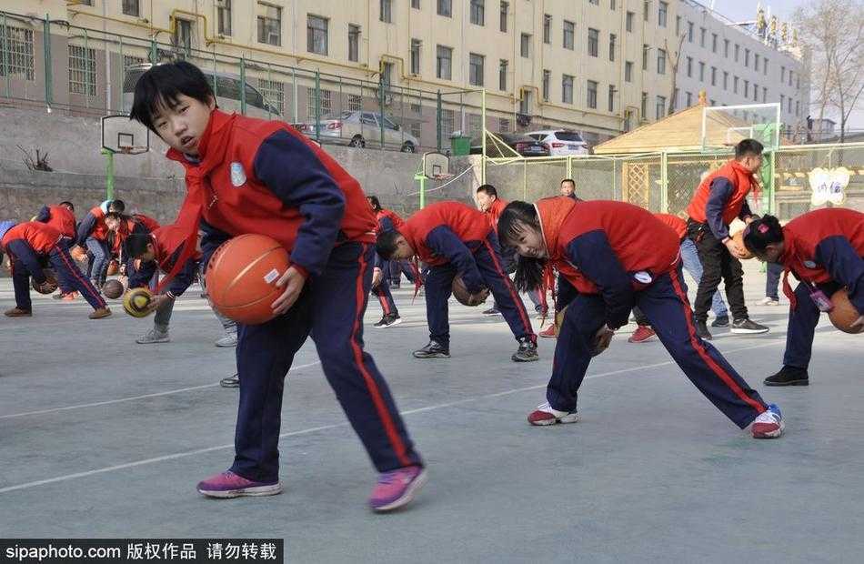 冬日的暖阳洒满校园，近千名小学生整齐列队，他们手中的橙色篮球仿佛跳动的火焰，瞬间点燃了整个操场的热情。