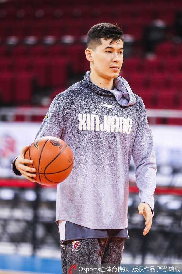 西热力江蹲坐在场边，用手轻托下巴，眼神专注地观察着场上队友的训练，此刻的他更像一位球场指挥官