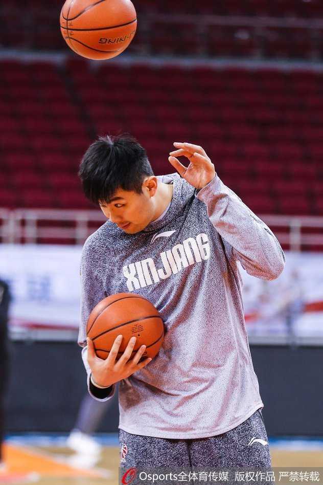 西热力江双手紧握训练服，置于身后，抬头挺胸望向训练馆的天花板，仿佛在进行赛前的最后冥想与自我激励